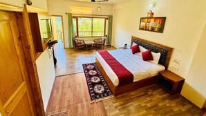 A bedroom with a bed, a nightstand, a desk, and a chair. - The Manrals Resort (Manali)