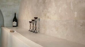 Una habitación con una mesa blanca, una botella de vino y candelabros.