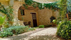 Un edificio de piedra con una puerta y una pequeña mesa afuera.