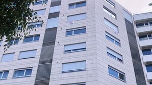 Een meerlaags gebouw met een modern architectonisch ontwerp, met een combinatie van raamstijlen en een opvallende verticale strook van afwisselend ramen en muren.