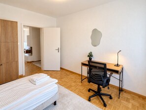 Ein Schlafzimmer mit einem Bett, einem Schreibtisch und einem Stuhl.