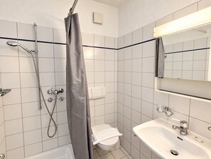 A bathroom with a shower, toilet, and sink. - Stylish 2-Bedroom Apartment with Stunning Views of Zurich - Tilia 41 (Zürich)
