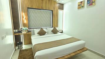 A modern hotel room with a bed, bedside table, and a large window.