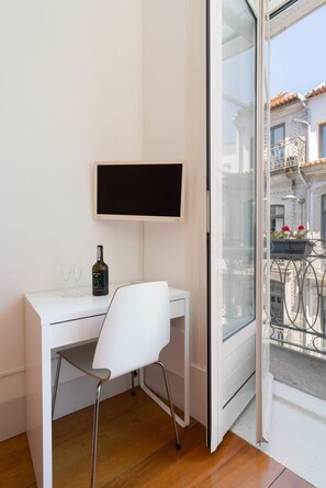 A white desk with a chair, a bottle of wine, and a TV on the wall. - Porto Lounge Hostel - 8 Private Room | Terrace (Porto)