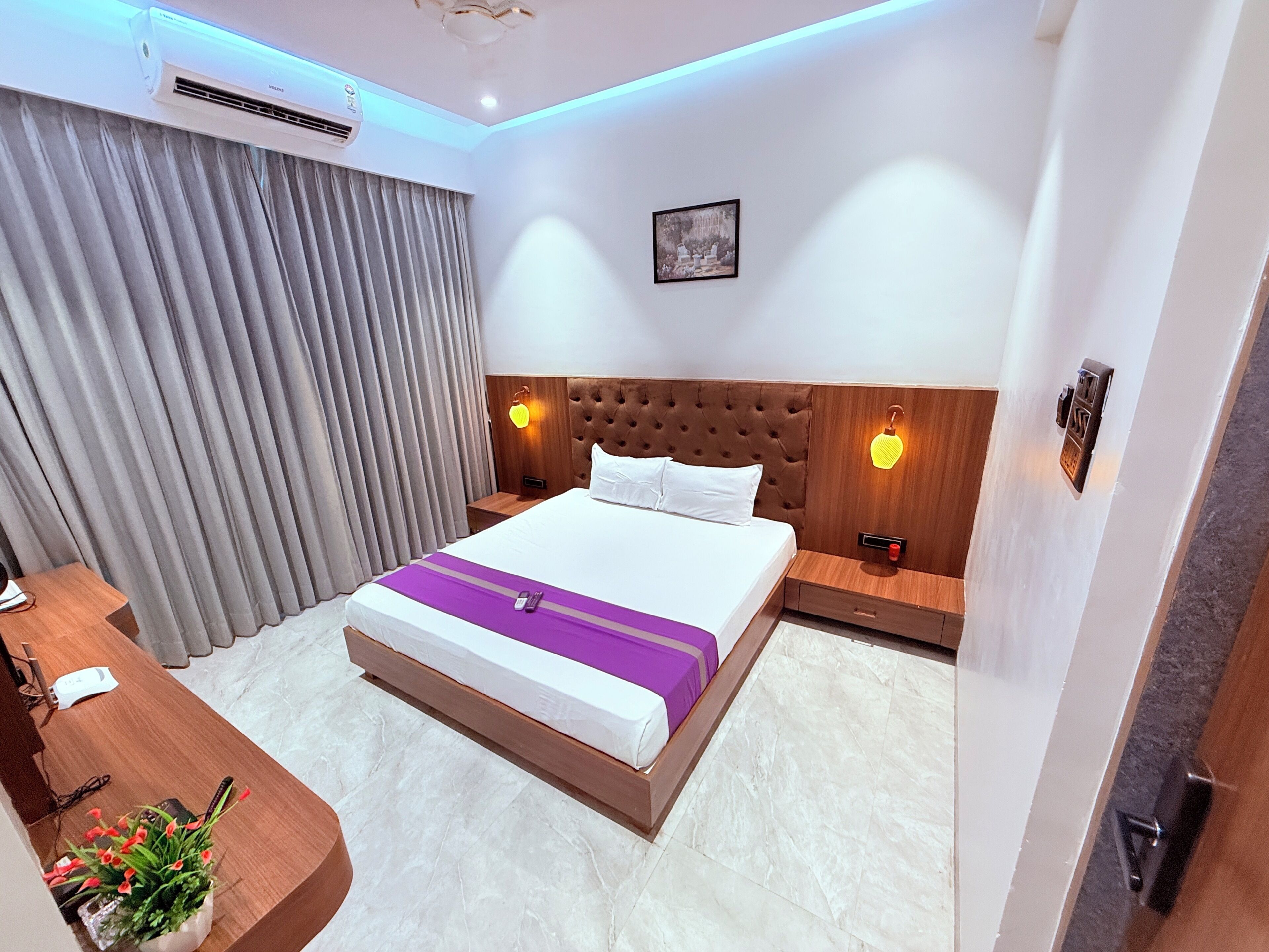 Una habitación de hotel con cama, mesitas de noche, un escritorio y una silla.