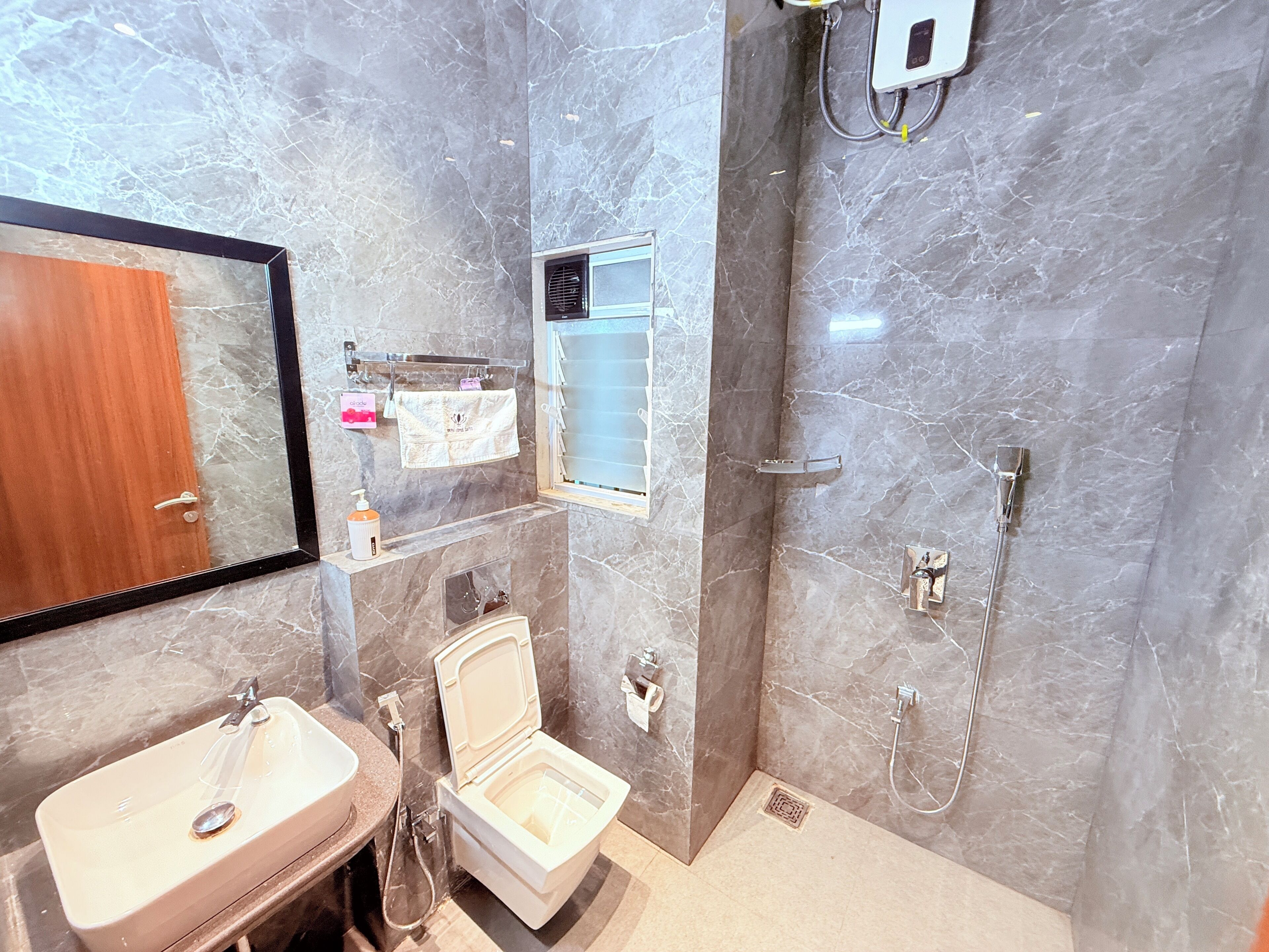 A bathroom with a toilet, sink, and shower.