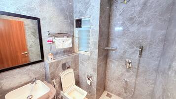 A bathroom with a toilet, sink, and shower.