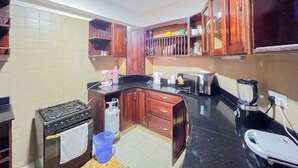 Cuina amb armaris de fusta, fogó a gas, microones i cafetera.