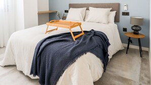 A bedroom with a bed, bedside tables, an air conditioner, and wall art. - AS EXT Fgrl Rferial 4 (Fuengirola)