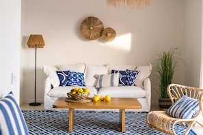 A living room with a sofa, a coffee table, a floor lamp, and a potted plant. - Refugi Blau, sea view in Son Bou (Son Bou)