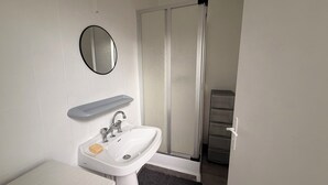 A bathroom with a white sink, a mirror, and a towel rack. - Apartment in Soulac town center, all on foot (Soulac-sur-Mer)