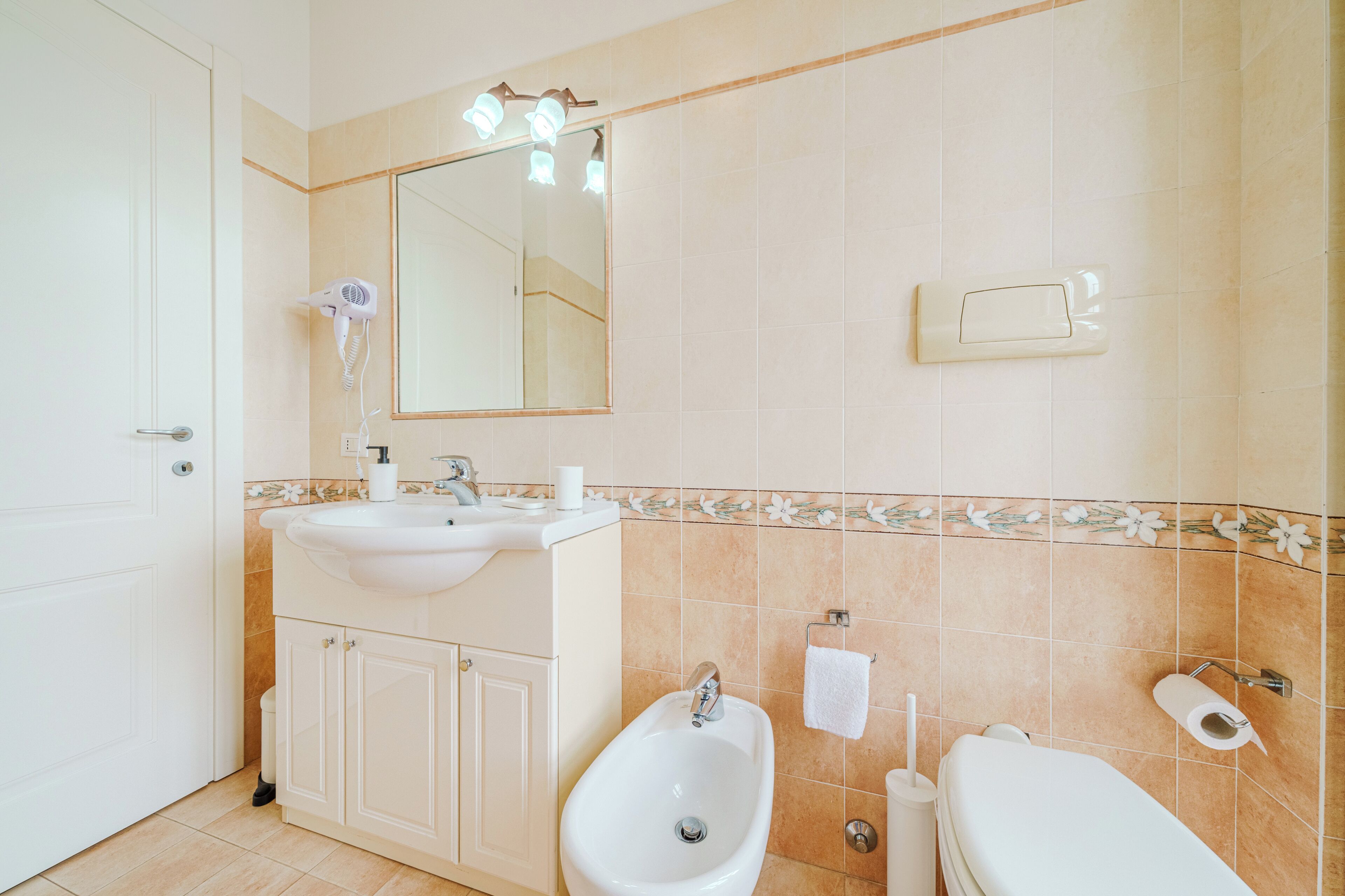 Ein Badezimmer mit Waschbecken, Bidet, Toilette und Spiegel.