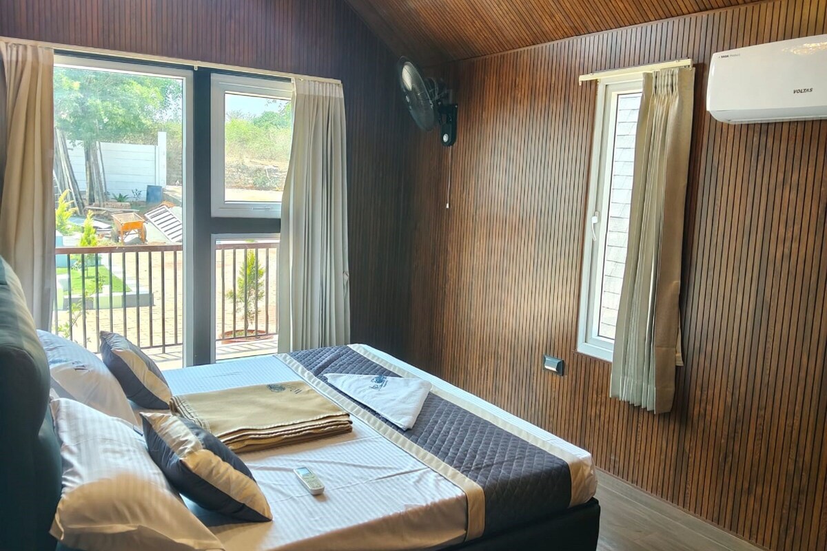 Una habitación con cama, ventana con cortinas, ventilador de techo y aire acondicionado.