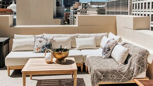 Eine Dachterrasse mit Sofagarnitur, Couchtisch und dekorativer Schale.