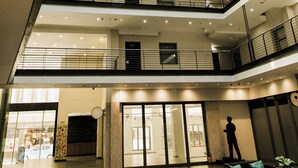 Ein mehrgeschossiges Atrium mit einem offenen zentralen Bereich, Geländern und einer Sitzecke.