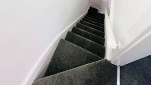 Eine Treppe mit Teppichstufen, die zu einer Zwischenebene führt.