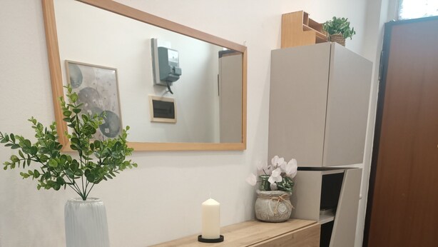A wooden console table with a vase, candle, and potted plants. - Valle dei Casali House is 5 minutes from Villa Pamphili and 15 minutes from the Vatican. (Roma)