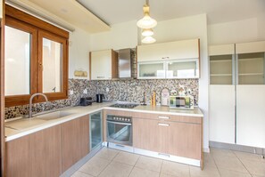 A modern kitchen with a built-in dishwasher, a coffee maker, and a vintage radio.