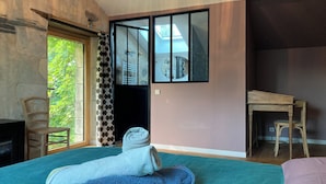 Ein Zimmer mit einem Bett, einem Schreibtisch, einem Stuhl, einem Fenster mit Blick und einer Tür.