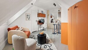 Ein modernes Loft mit hohen Decken, einem Essbereich mit Bar und einer gemütlichen Sitzecke mit Sofa und Sesseln.