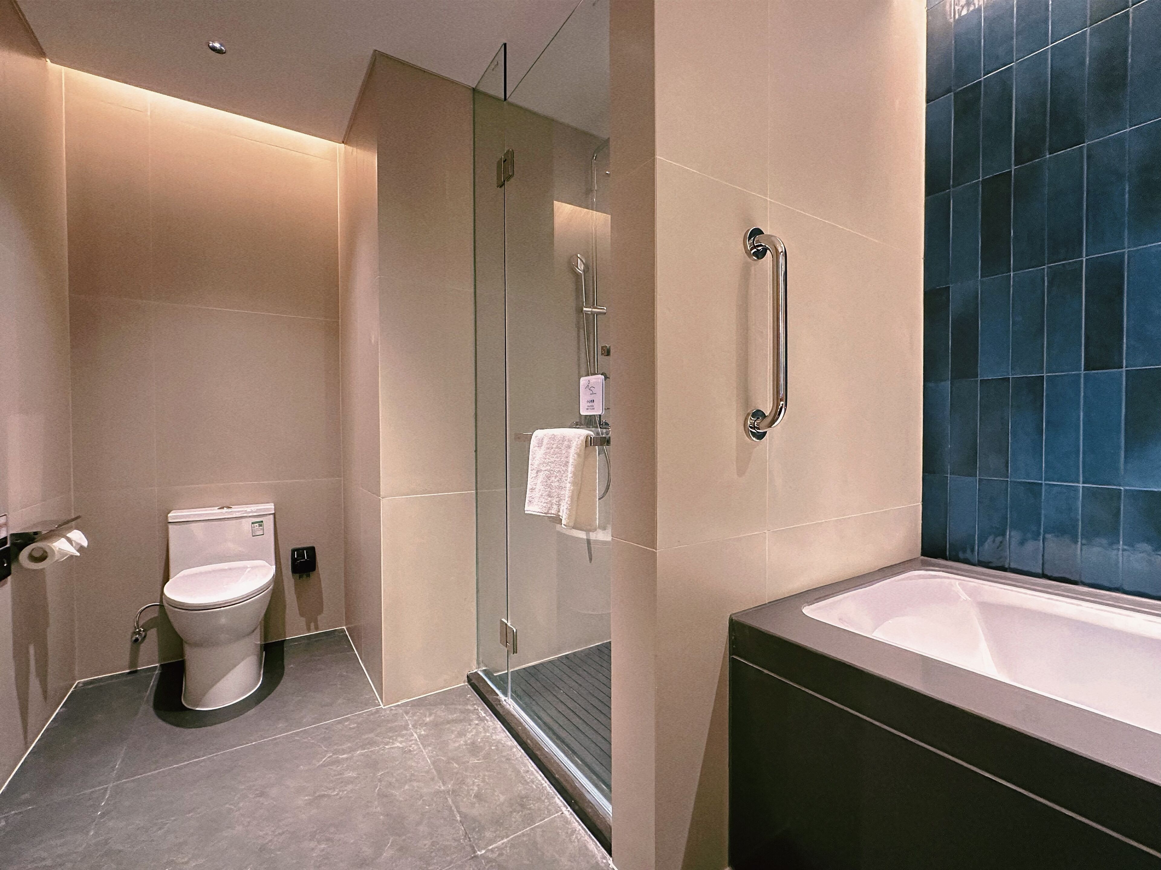 Un baño moderno con cabina de ducha de vidrio, inodoro y bañera.