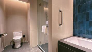 Un baño moderno con cabina de ducha de vidrio, inodoro y bañera.