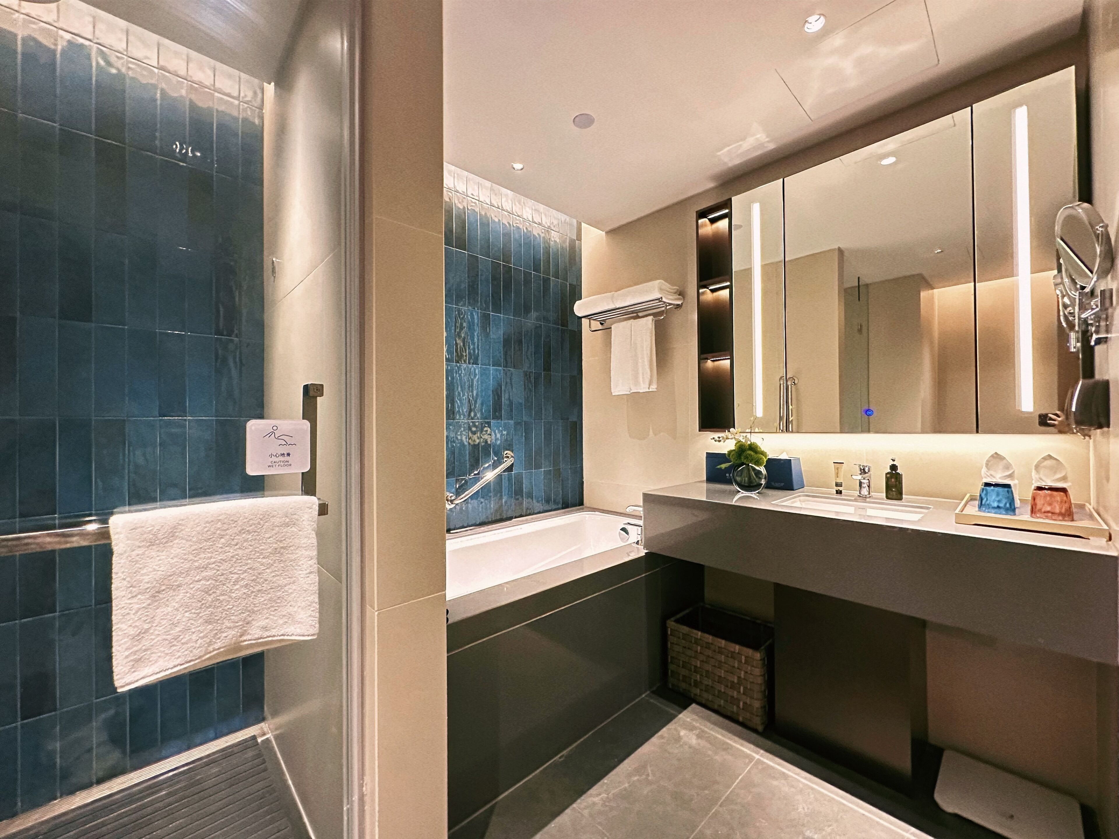 A modern bathroom with a bathtub, a sink, and a large mirror.