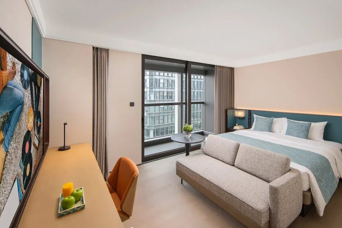 Une chambre d’hôtel avec un lit, un canapé, un bureau et une fenêtre.