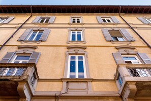 A building facade with multiple windows, decorative moldings, and a balcony with metal railings. - Room 2 with Wi-Fi in Como (Como)