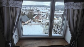 Une pièce dotée d’une grande fenêtre donnant sur un paysage enneigé.