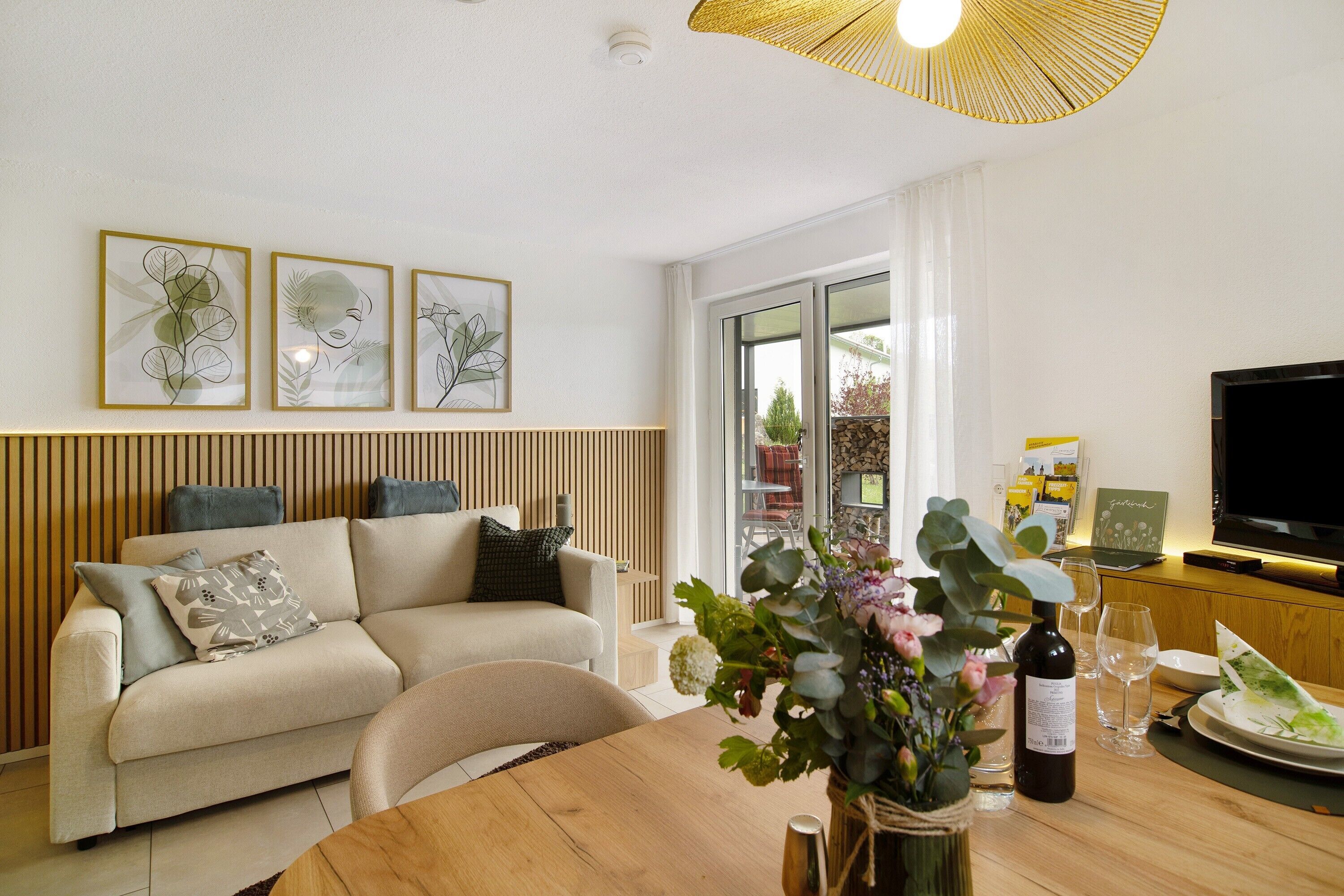 Una sala de estar moderna con sofá, mesa de comedor y una obra de arte en la pared.
