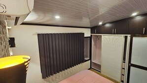 Quarto com radiador, cortina, guarda-roupa e pia.