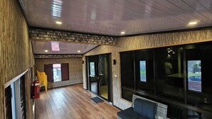Um interior moderno com paredes e piso de madeira, e janelas amplas.