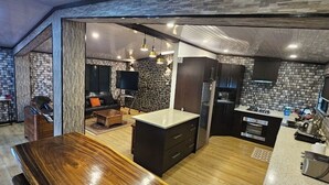 Uma sala de estar integrada com cozinha, mesa de jantar e sofá.