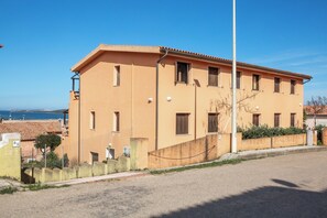 Ein zweistöckiges Gebäude mit flachem Dach, zahlreichen Fenstern und einer sichtbaren Straßenlaterne.