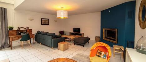 A modern living room with a sofa, coffee table, and a unique orange bean bag chair.