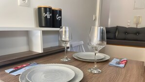 Mesa de jantar com dois pratos, duas taças de vinho e um guardanapo dobrado com um garfo.