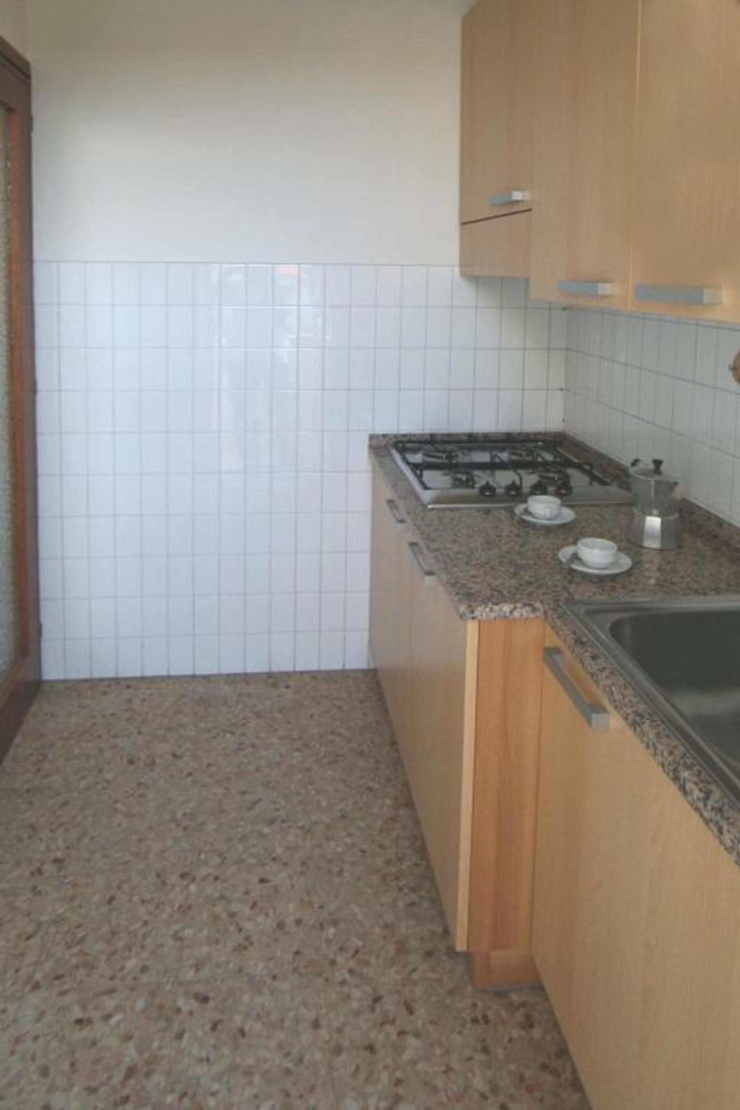 Una cocina con estufa a gas, pileta y mesada.