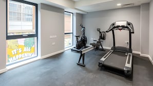 A gym with a treadmill, elliptical, and weight bench. - Student Only Straits Aire (Leeds)