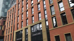 A multi-story building with a prominent 'Straits Aire' sign, large windows, and a modern architectural style. - Student Only Straits Aire (Leeds)