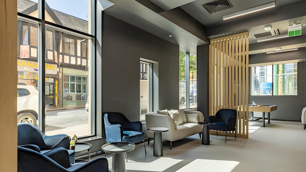 A modern lobby with seating, large windows, and a view of the street. - Student Only Straits Aire (Leeds)