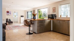 A modern kitchen with a dining area, large windows, and a view of the outdoors. - Stunning 1 Bedroom Home in Worcestershire (Hillside)
