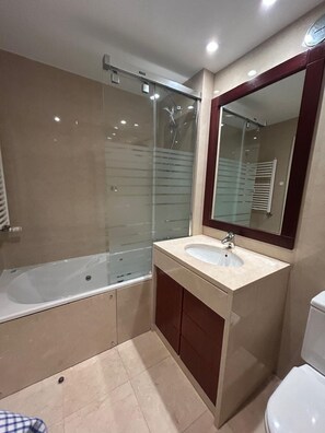 A modern bathroom with a bathtub, a sink, and a toilet. - Areeiro Elegant by Homing (Lisbon)