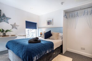Ein Schlafzimmer mit Bett, Nachttisch, Fenster mit Aussicht und einer Stern-Dekoration an der Wand.