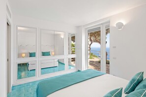 Ein Schlafzimmer mit Bett, Fenster und Meerblick.