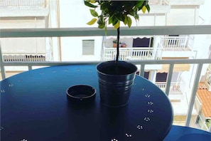 A balcony with a potted plant, a metal bucket, and a railing. - Wyn-cozy Studiostniarchos Foundation Near the Sea (Kallithea)