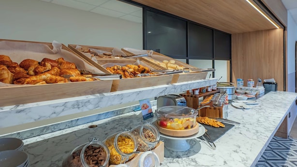 Un buffet proposant une variété de plats, notamment des pâtisseries et des fruits.