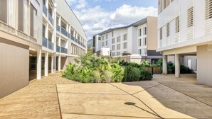 A courtyard with modern buildings, a central garden, and a clear sky. - B&B Hotel La Réunion Aéroport (Sainte Marie)