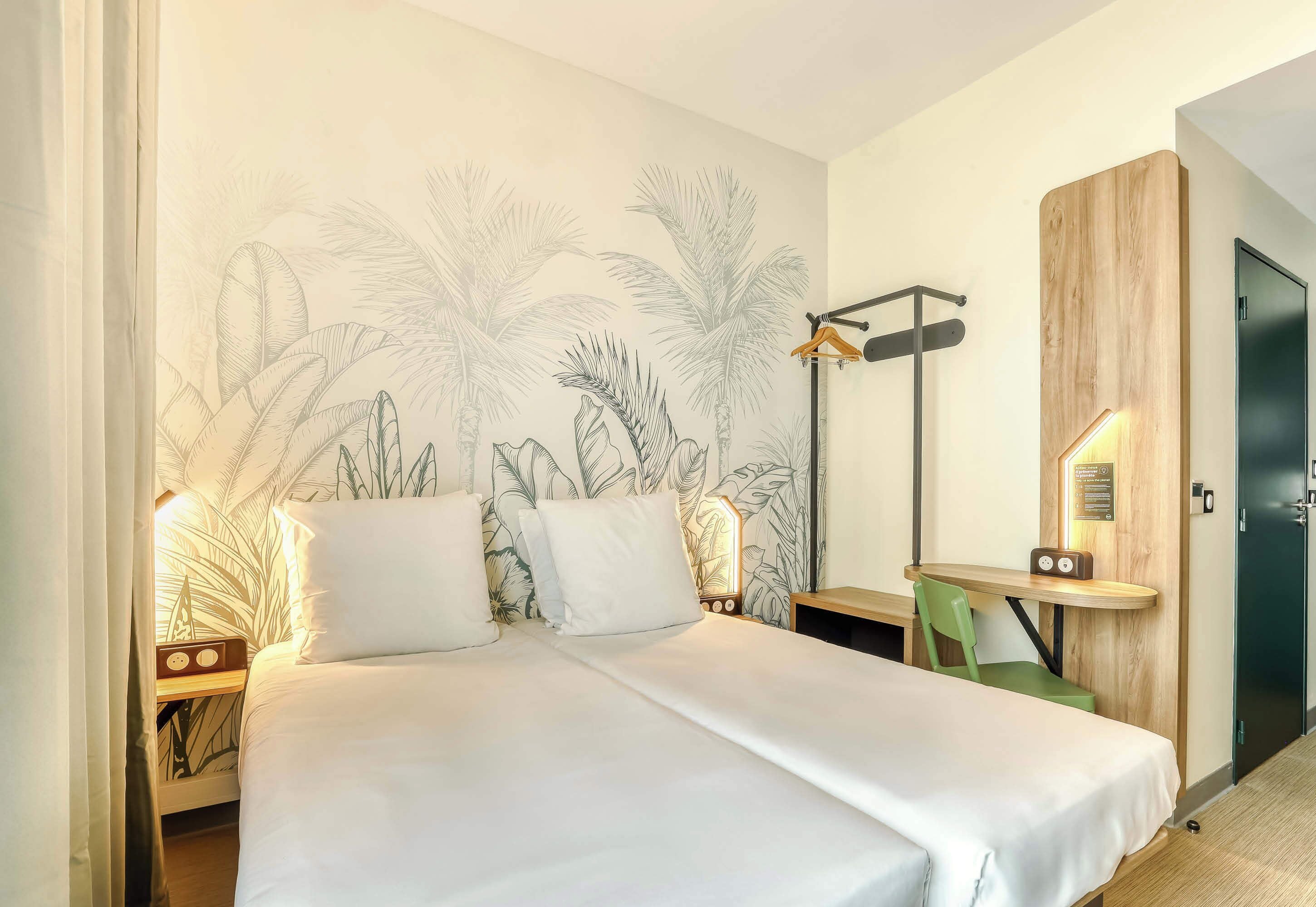 A bedroom with a bed, a nightstand, a bedside table, a chair, a desk, and a wardrobe.