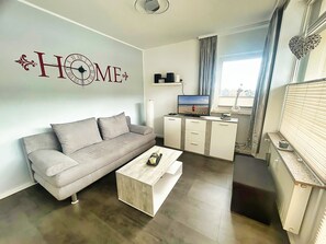 TV, DVD player - Stylish vacation apartment Seeluft in Großenbrode. Balcony with wonderful sea view. Family-friendly furnishings and maximum sleeping comfort in a box-spring bed. Practical washing machine and iron (Großenbrode)